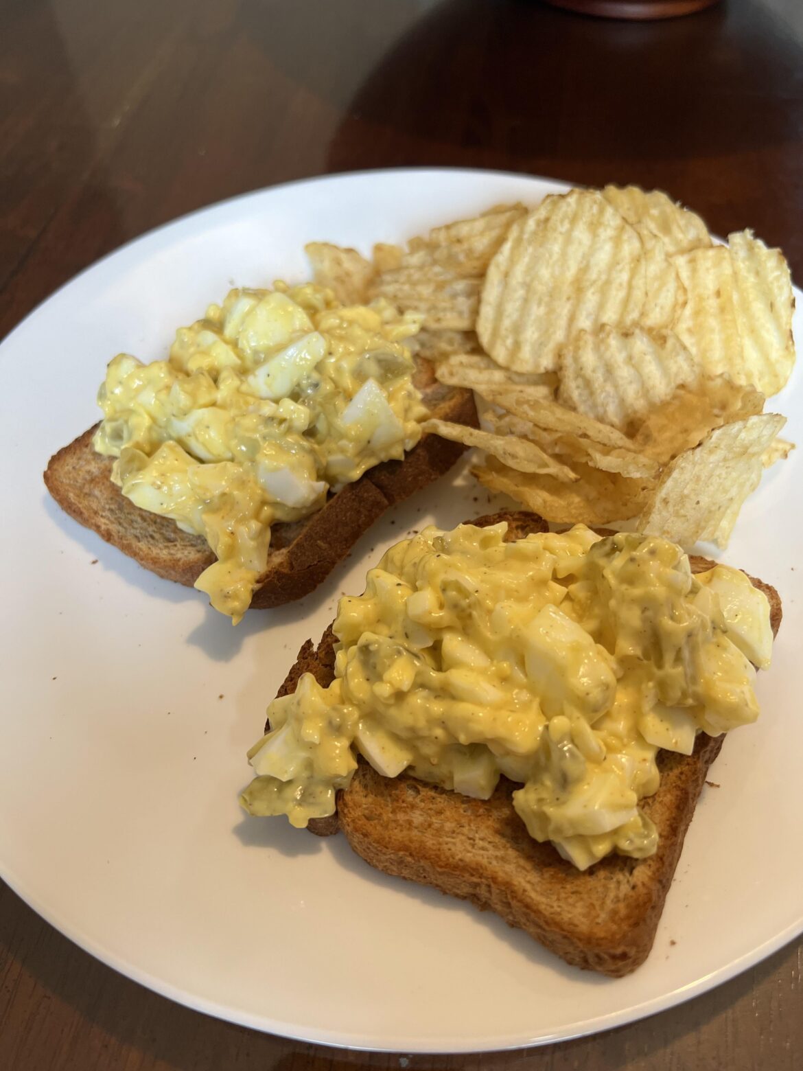 Egg salad with chopped sweet pickle on wheat toast