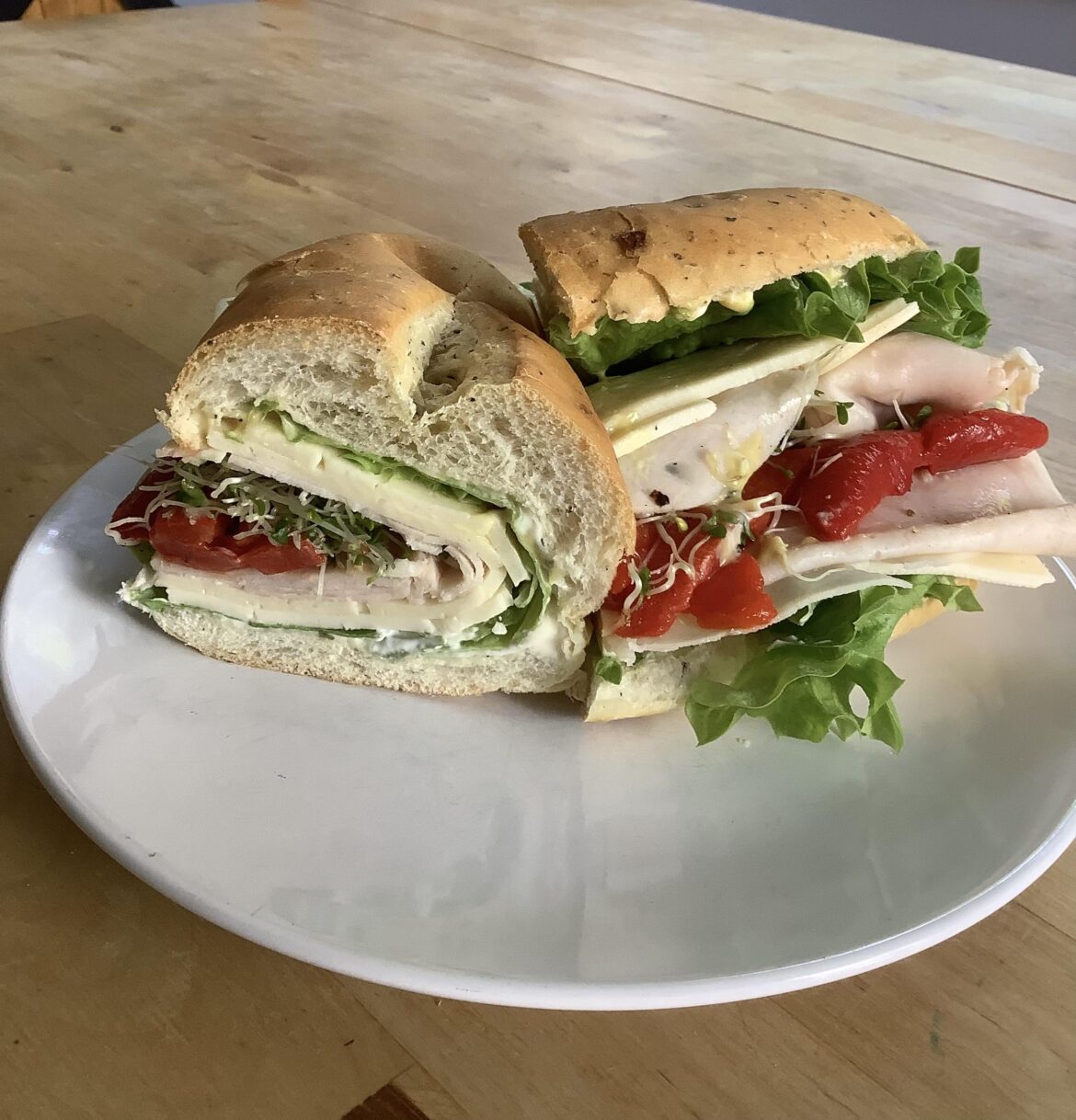 Smoked chicken & havarti with roasted red pepper , lettuce & sprouts . Mayo , mustard on a herb roll.