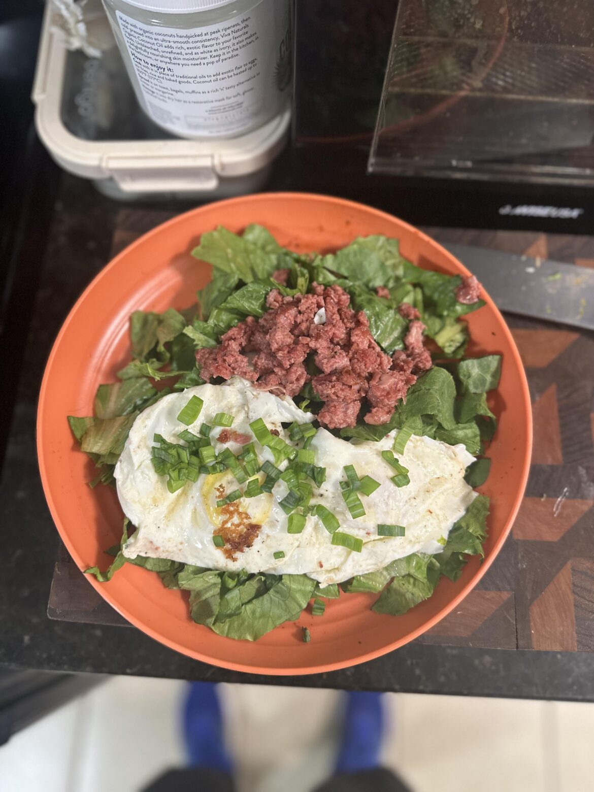 Eggs and corned beef on lettuce with green onions.