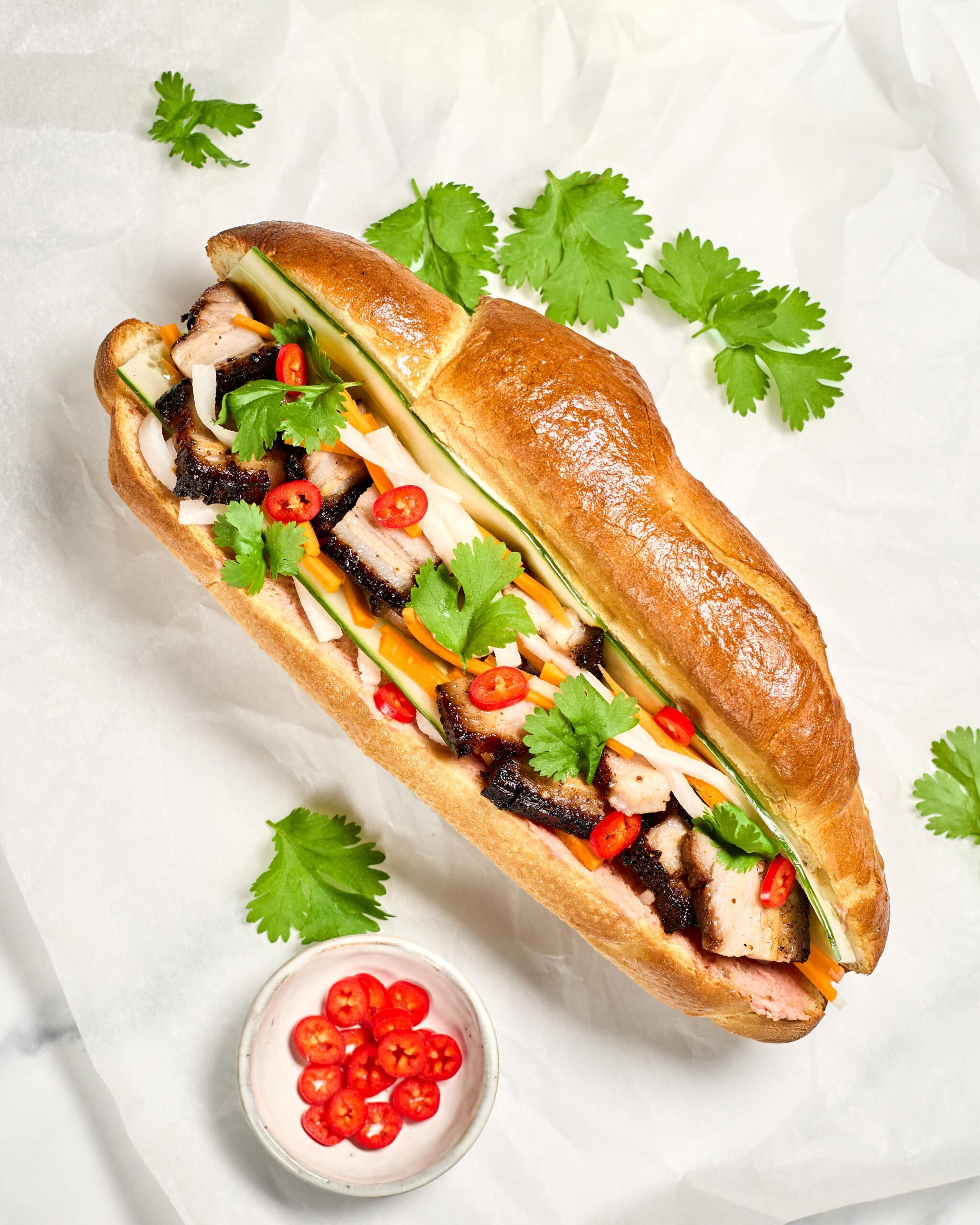 Homemade bánh mì with pork belly, pickled carrot & daikon, cucumber
