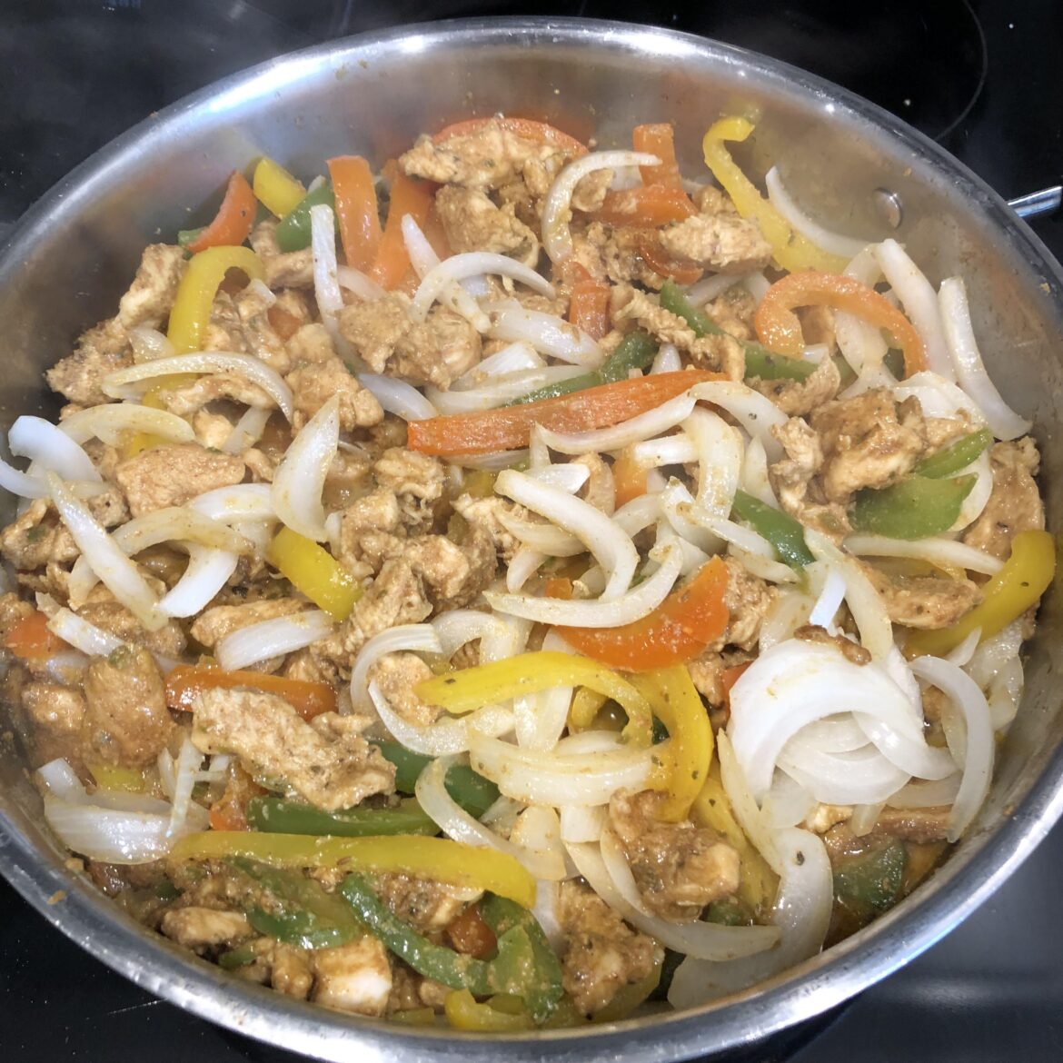 Chicken fajitas with peppers, ONIONS and jalapeños. Always put the onions in last!