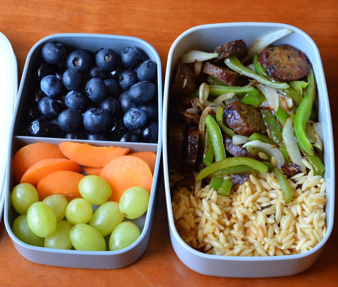 (337 cal, 19 P) Light lunch from last week: Tabitha Brown jalapeno sausages with onions and bell peppers, pasta rice, blueberries, apricot, grapes