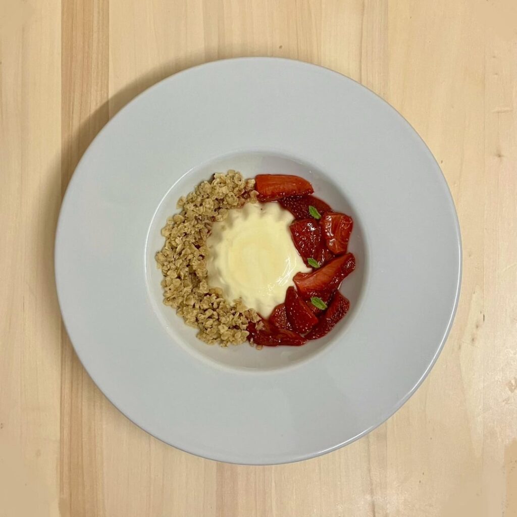 Burnt honey and lemon panna cotta, slow-roasted strawberries, oat crumb