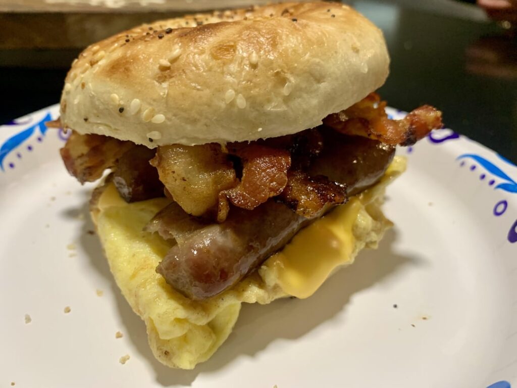 Egg, sausage, bacon and cheese on an everything bagel