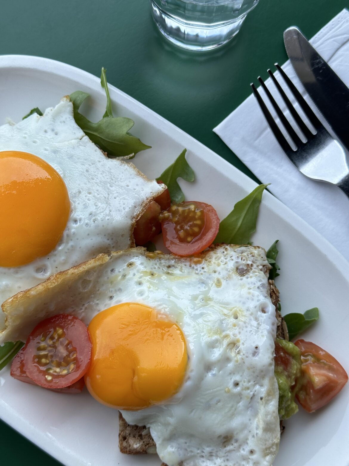 Avocado toast with cherry tomatoes, seagulls and sunny side up eggs