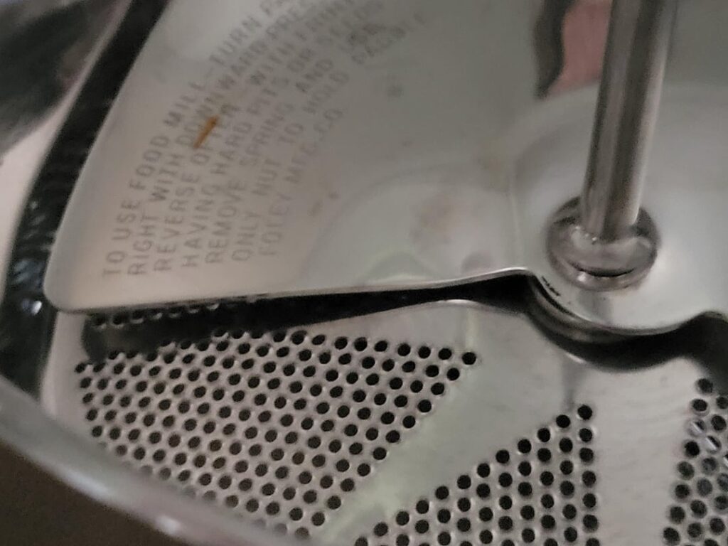 Bought "new" food mill on eBay and I think it's defective.  I've never had a new one before so I don't know if this one is bent or if all the other ones I have used have been bent.  The blade does not scrape against the bottom no matter how much pressure I put on it.  The nut is tight.  Help!