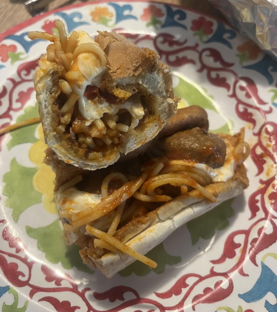 Meatball and spaghetti sub on a garlic bread roll with mozzarella.