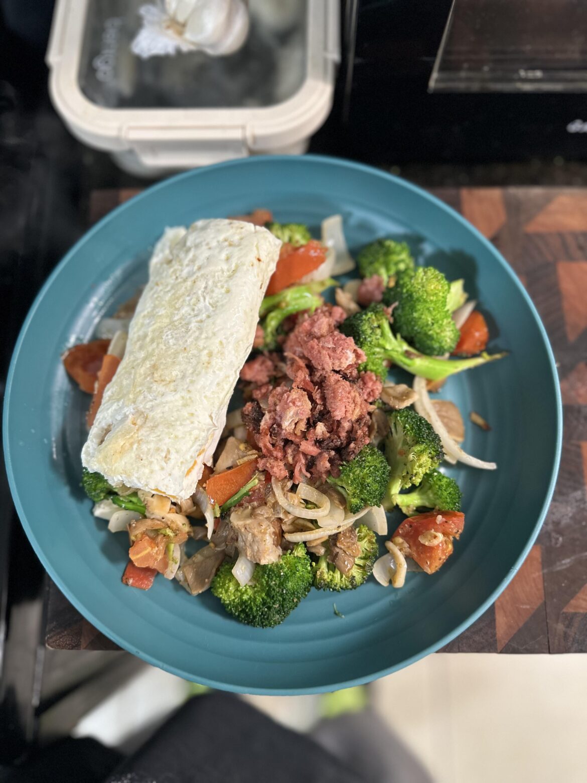 Japanese style rolled egg white omelette with cheese, corned beef, broccoli, onions, garlic, and tomato.
