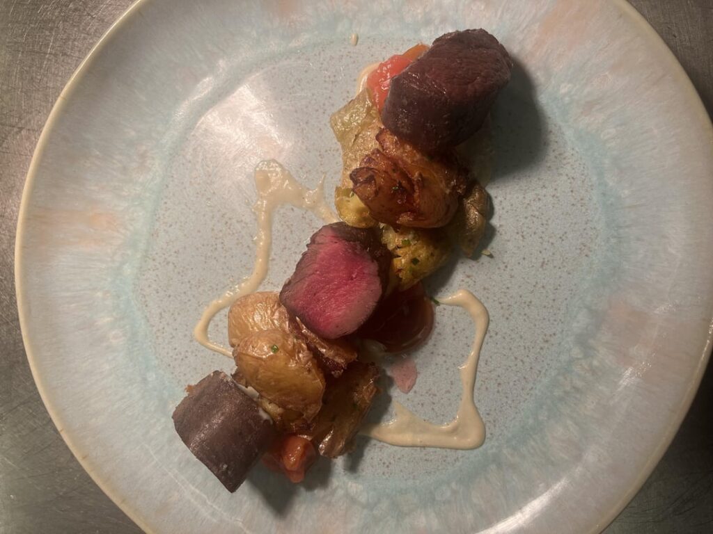 Venison loin with burnt juniper cream gravy, plum compote and smashed potatoes