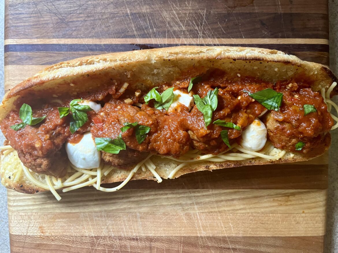 Spaghetti and meatballs on garlic bread sandwich.