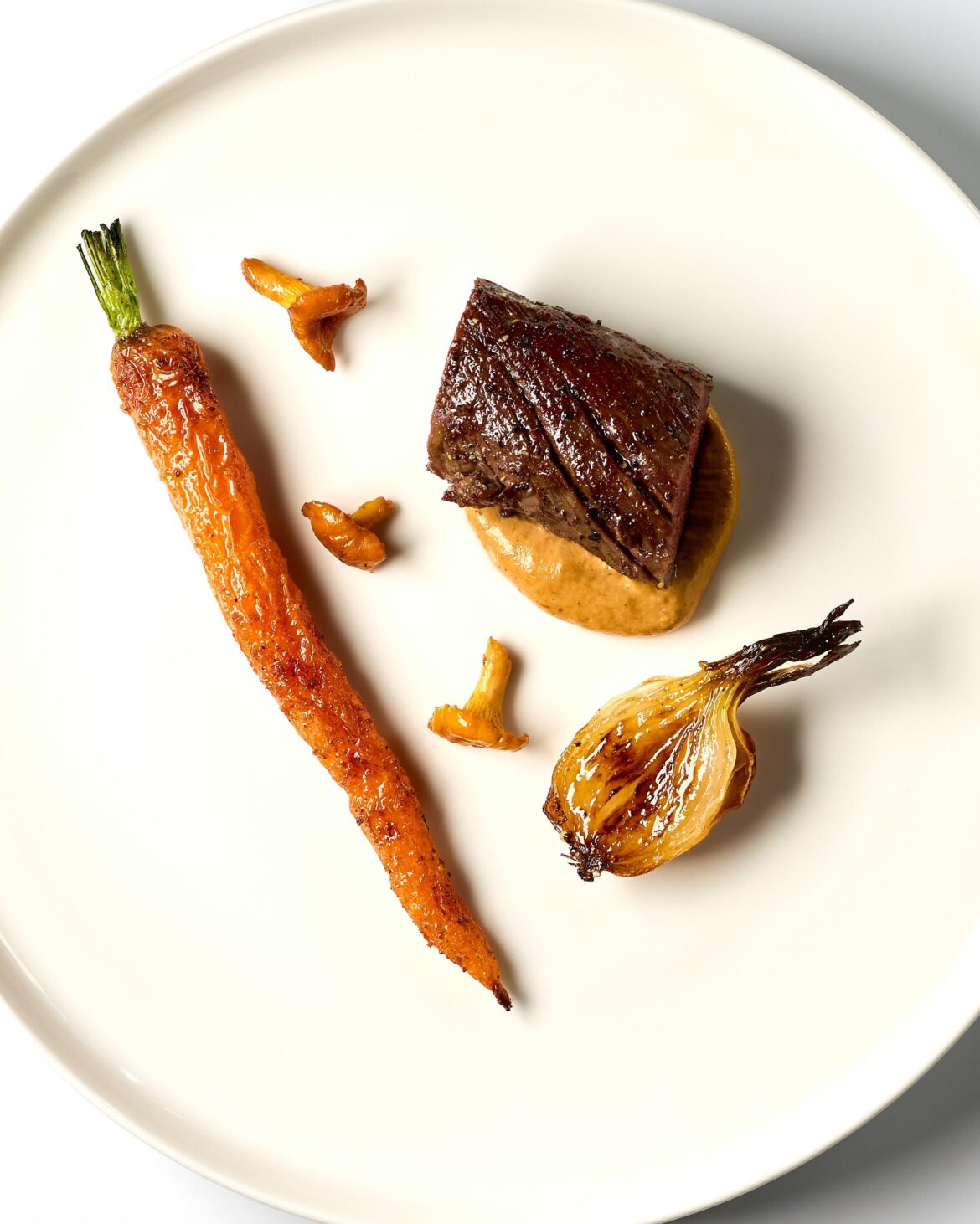 Reindeer with a chanterelle cream, oven baked carrot, caramelized summer onion and sautéed chanterelles