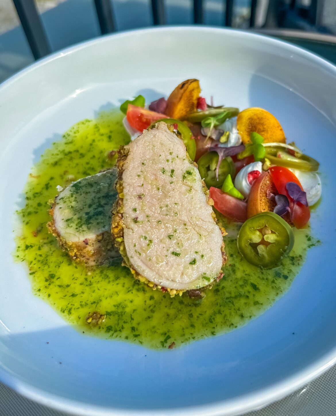 Honey mustard pistachio pork tenderloin, peach jalapeño caprese salad, basil oil.