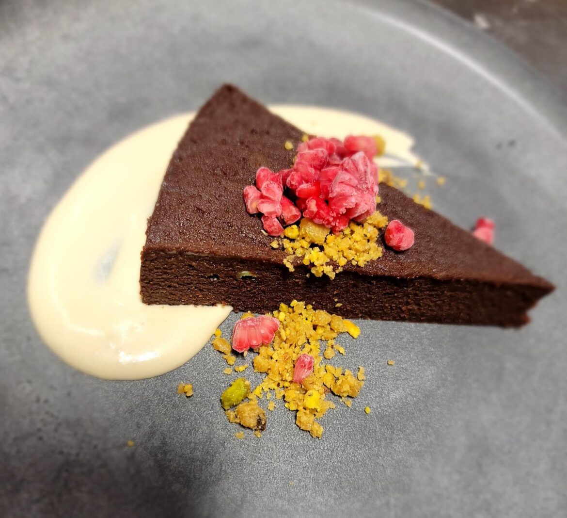 flourless chocolate cake with mocha cream, pistachio praline, and frozen raspberry segments