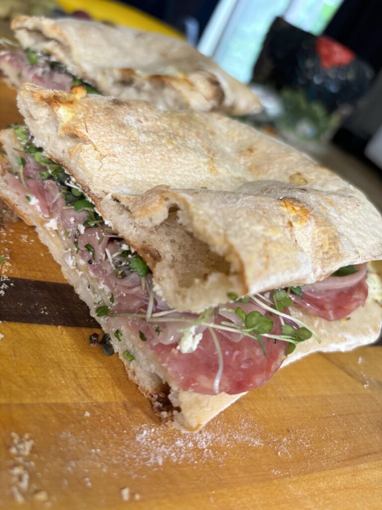 Prosciutto, sopressata, micro greens, garlic&herb goat cheese on homemade sourdough flatbread.