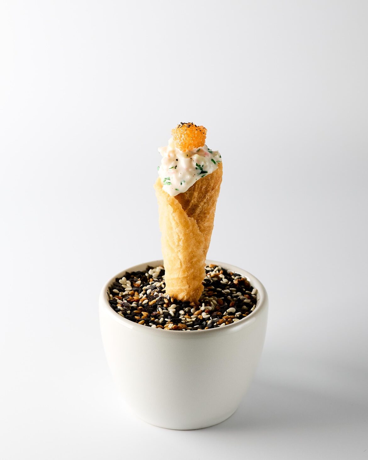 A twist on the Swedish classic "Toast Skagen": a cornet filled with caridean shrimp, mayonnaise, sour cream, dill, chives, lemon and cucumber. Topped with roe and black pepper. Inspired by the famous dish from The French Laundry.
