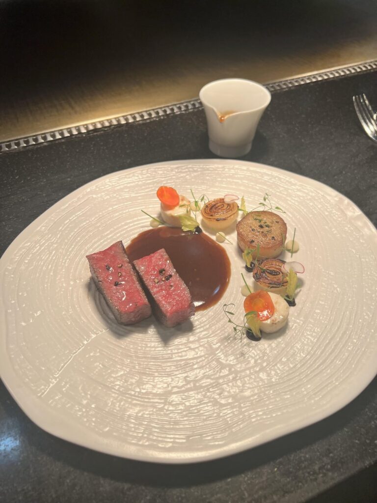 Australian wagyu ribeye, pommes fondant, charred confit onion, salt-baked celery root, black garlic purée, celery root purée, poured with poivre sauce