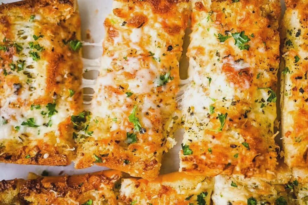 Ultimate Cheesy Garlic Bread: Crispy crust, gooey cheese, and roasted garlic goodness in every bite!