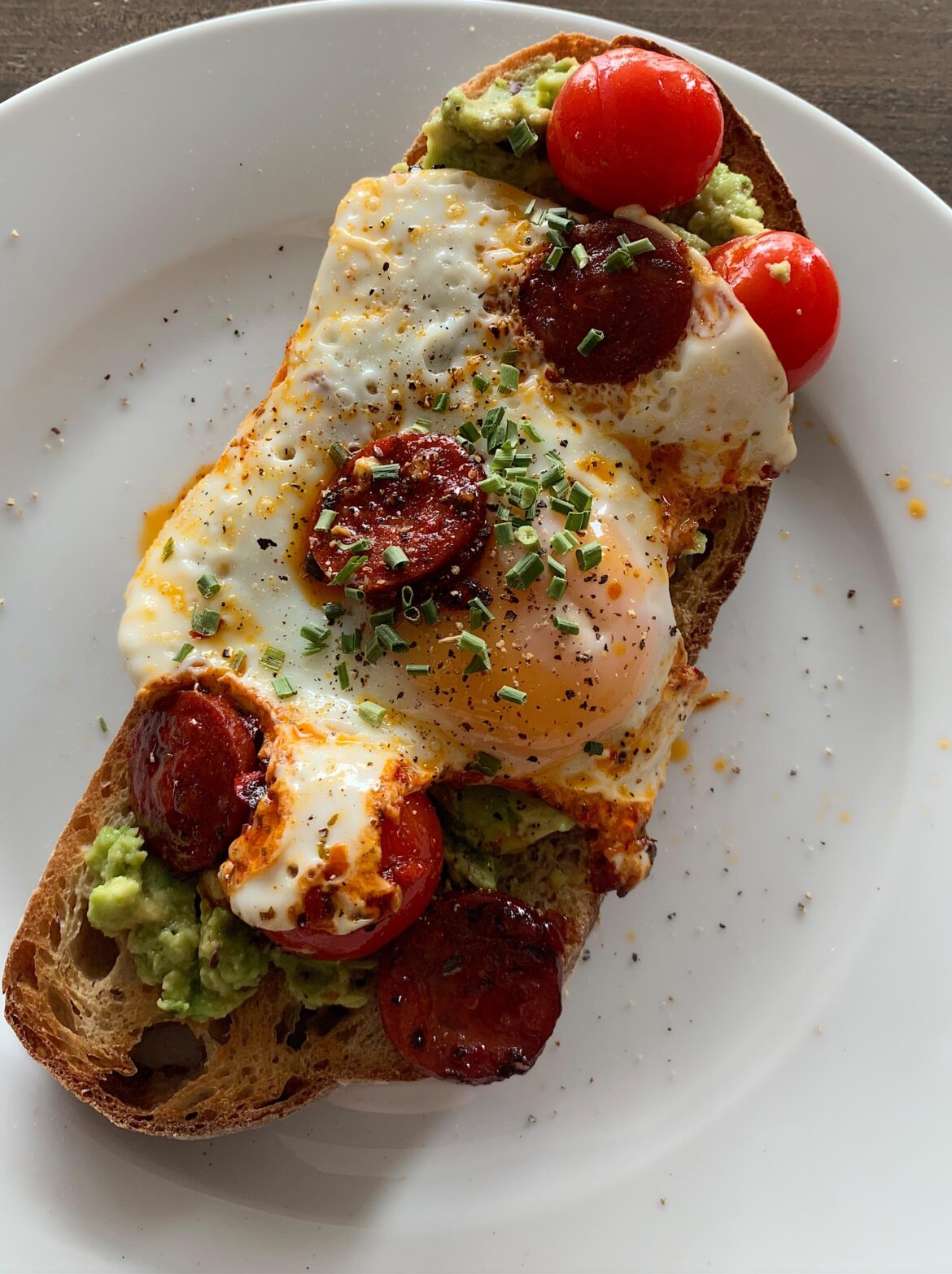 Fried egg, chorizo and cherry tomatoes on avocado sourdough