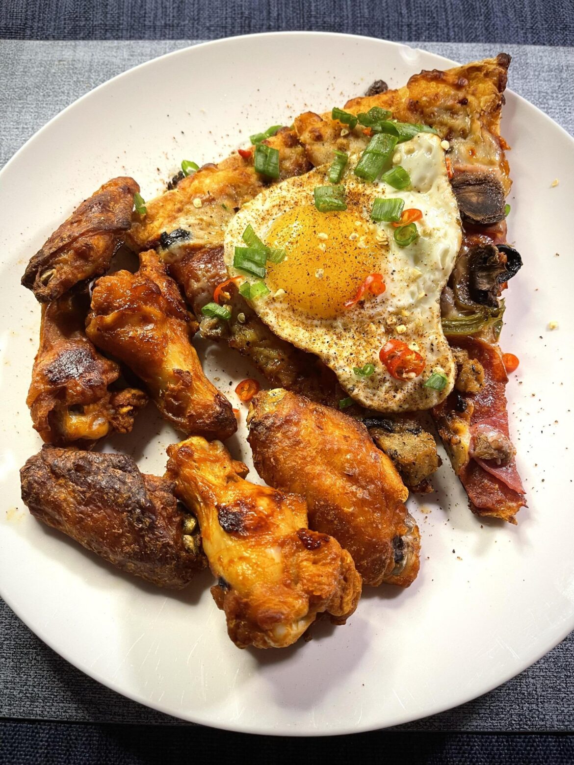 Left over pizza and chicken wings with a topper