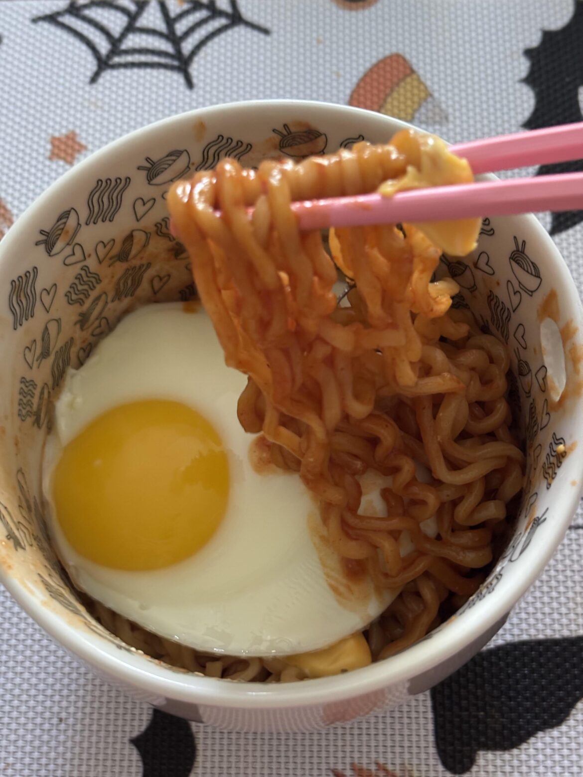 Buldak original ramen topped with a slice of American cheese and an egg. spicy and satisfying lunch.