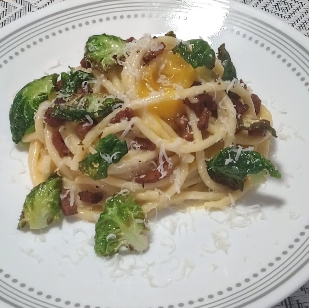 Bucatani Carbonara with Guanciale, Lemon Cured Egg Yolk, Fried Brussel Leaves