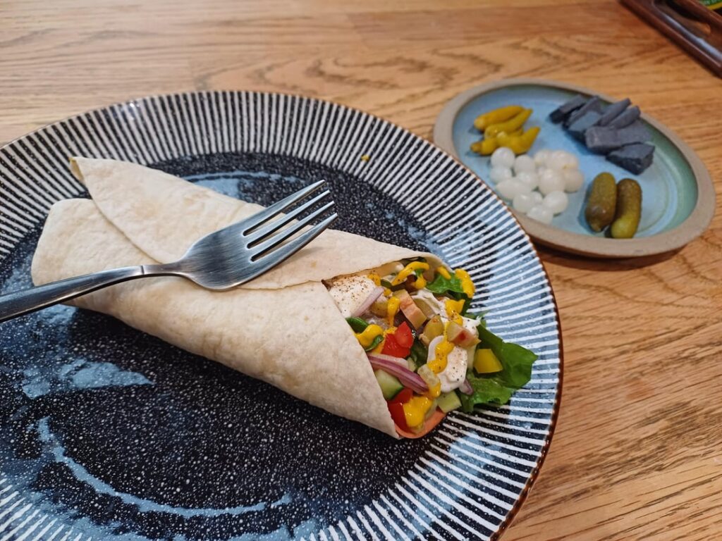 Ham salad wrap with a side of pickles and cheese ( 419 calories)