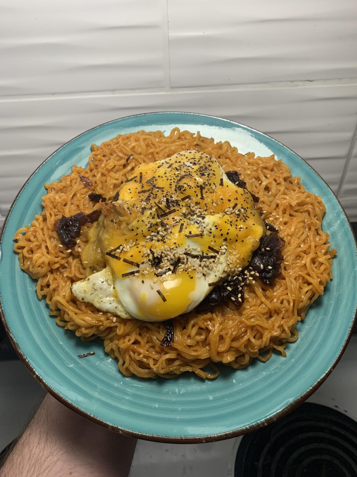 Two cheesey eggs on a bed of caramelized onion and spicy ramen.