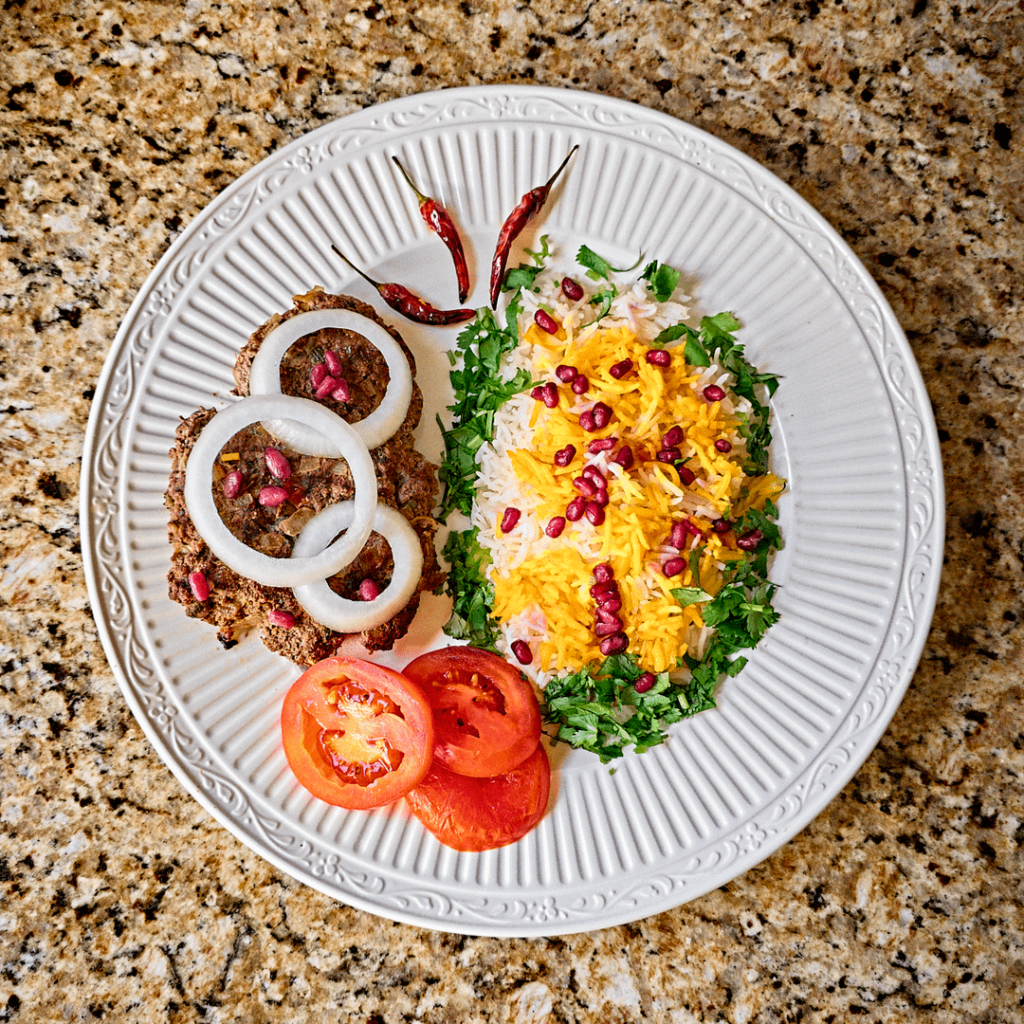 Keema Patty, Rice, Pomegranate Seeds, and Tomatoes.