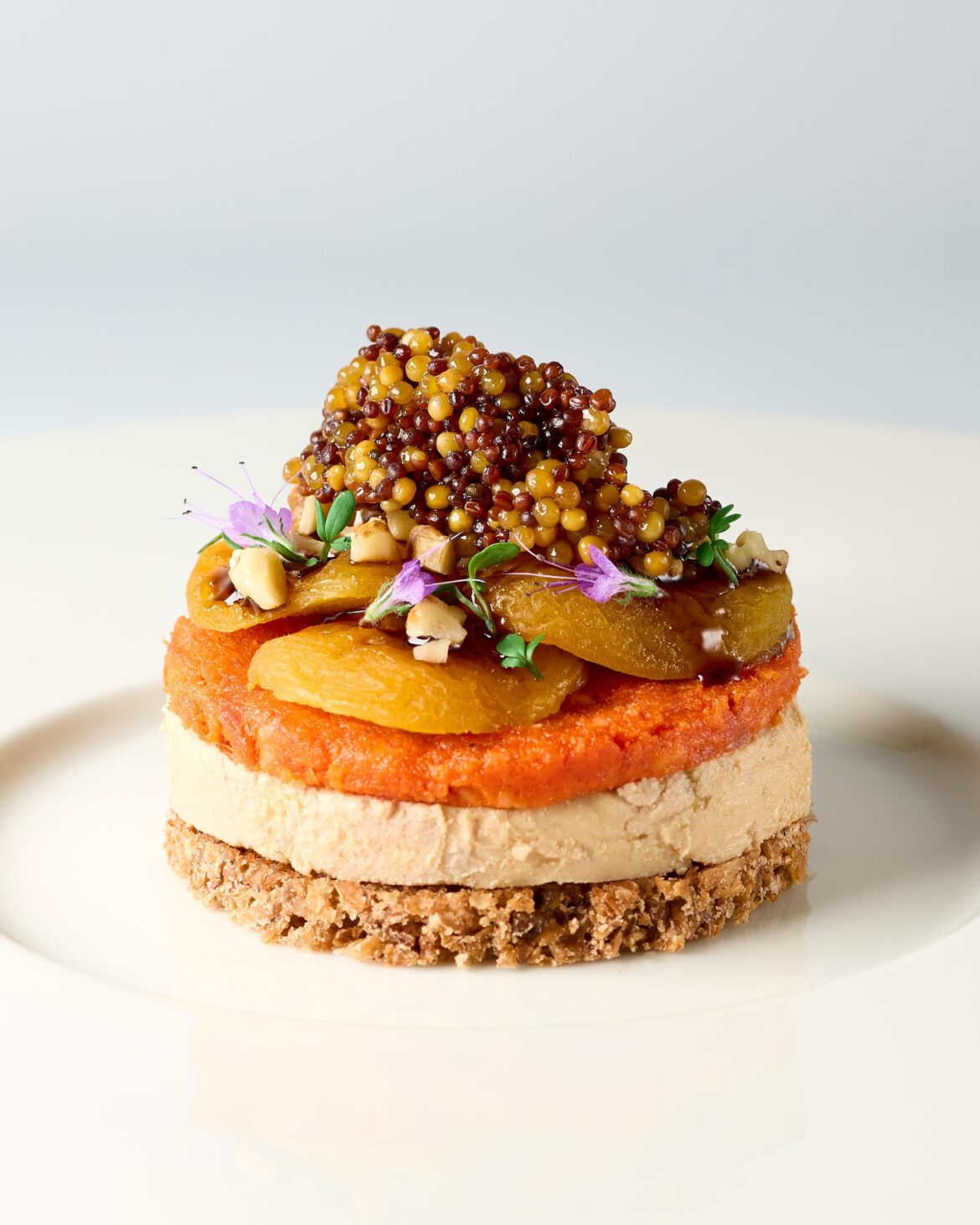 Rye bread, foie gras and sobrasada topped with dried apricots, pomegranate syrup, walnuts and fermented mustard seeds