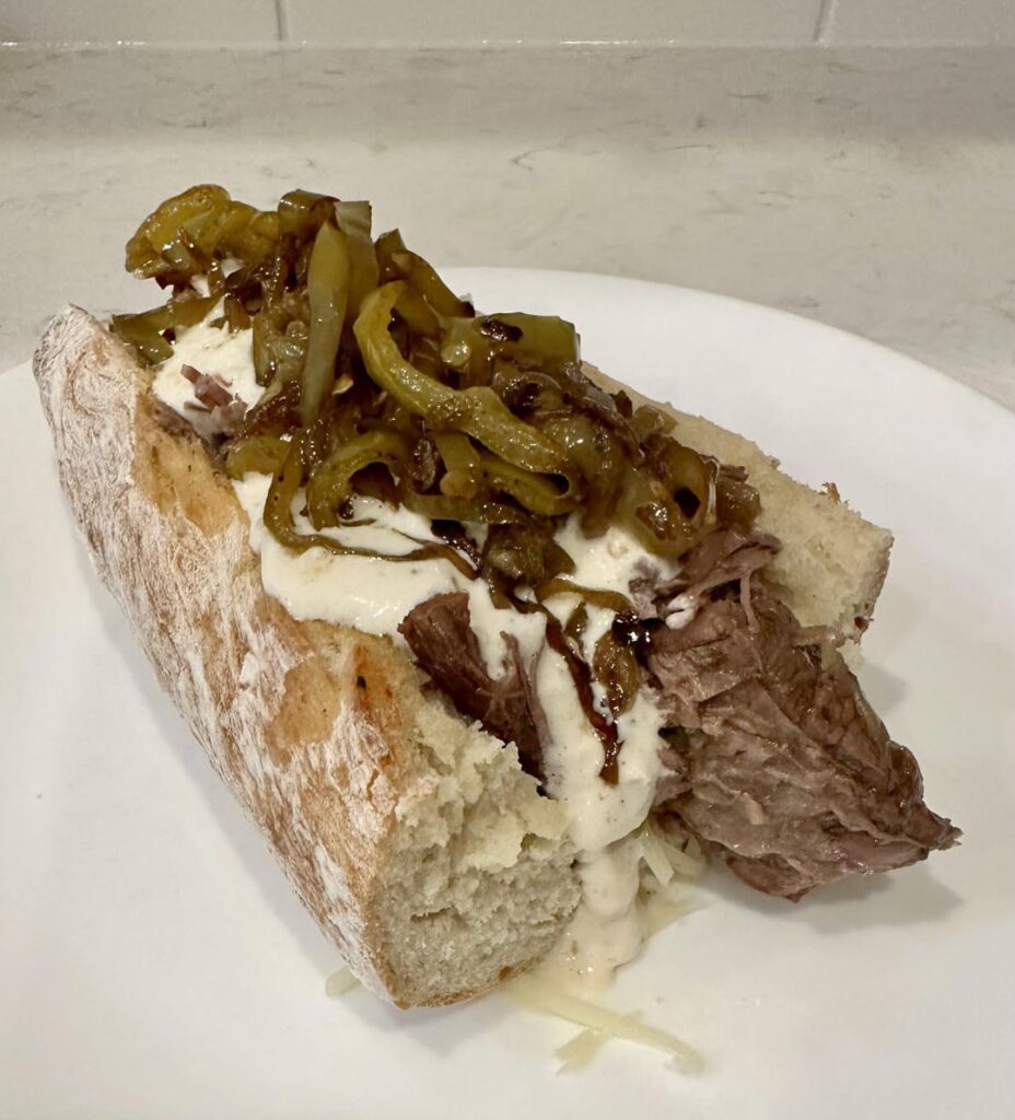 Braised Beef Cheesesteaks with Gruyère, caramelized peppers and onions, and horseradish sauce on fresh made baguettes