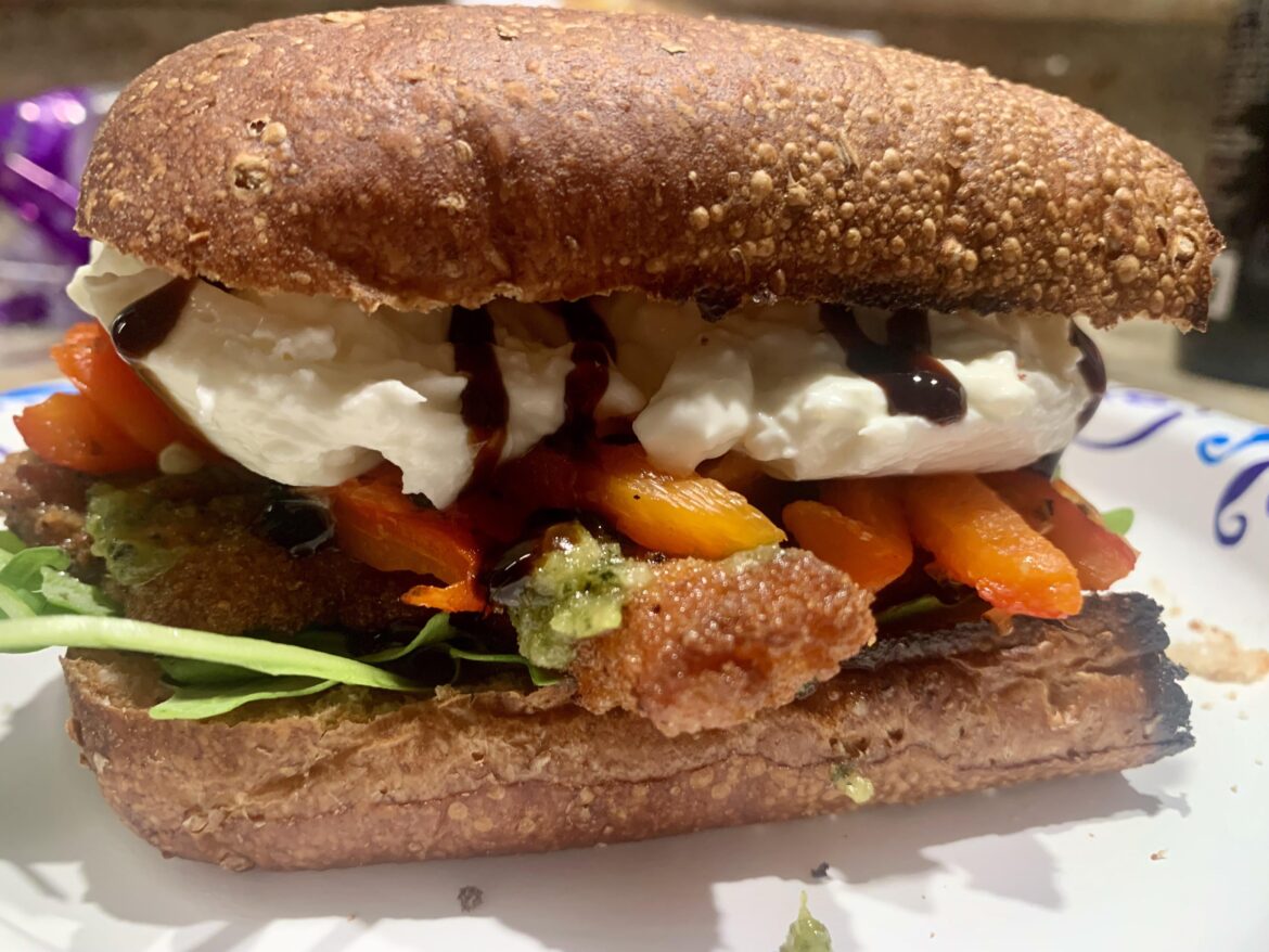 Chicken cutlet with pesto, arugula, grilled bell peppers, burrata cheese, and balsamic glaze