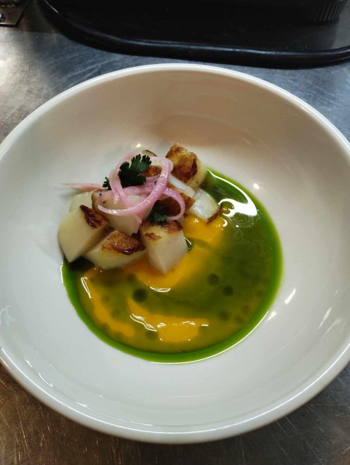 Scallop, carrot, aji amarillo, red onion pickled in rhubarb vinegar, cilantro, herb oil