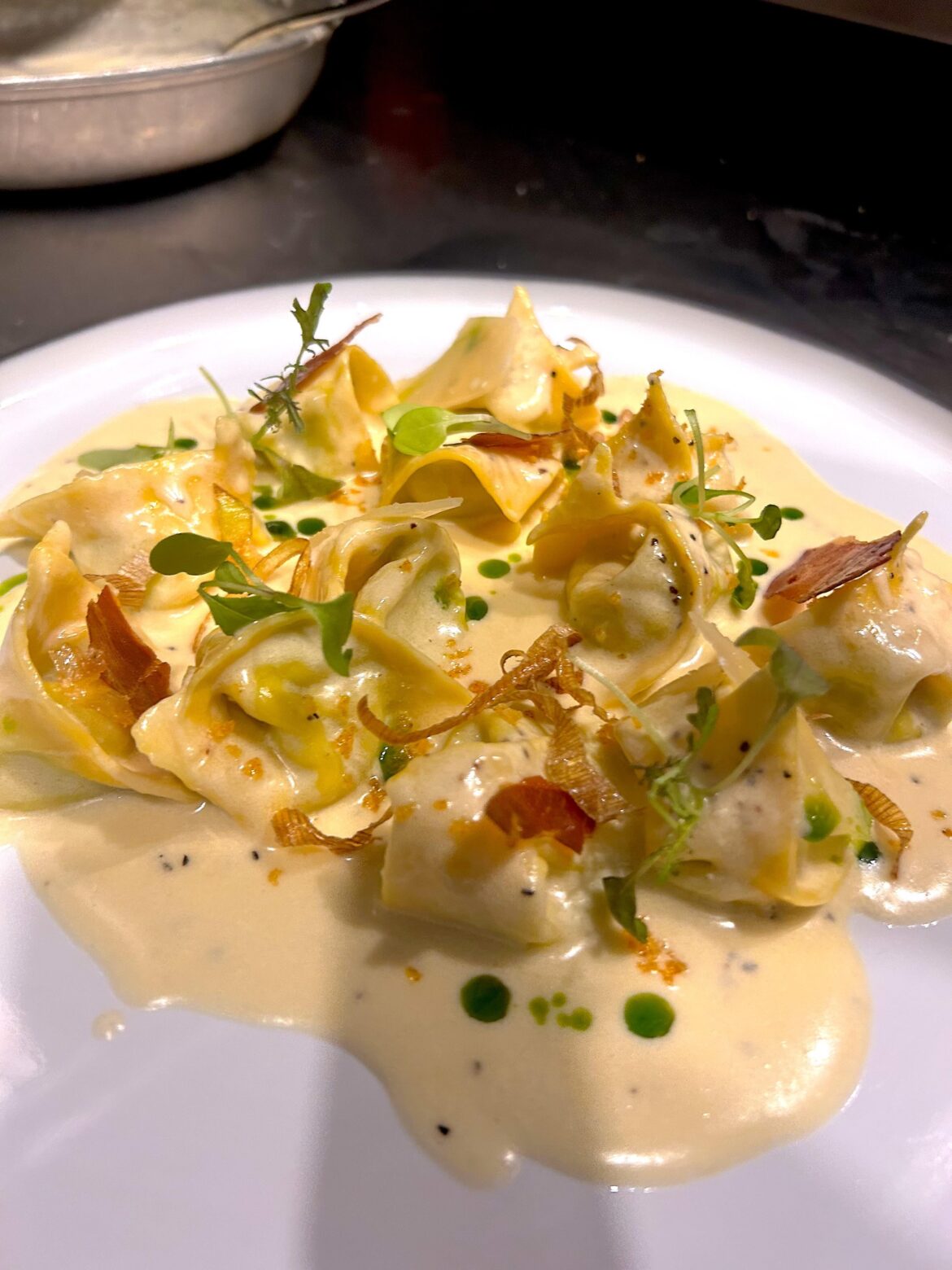 Pea Tortellini with creamy parmesan sauce, prosciuto chips and basil oil
