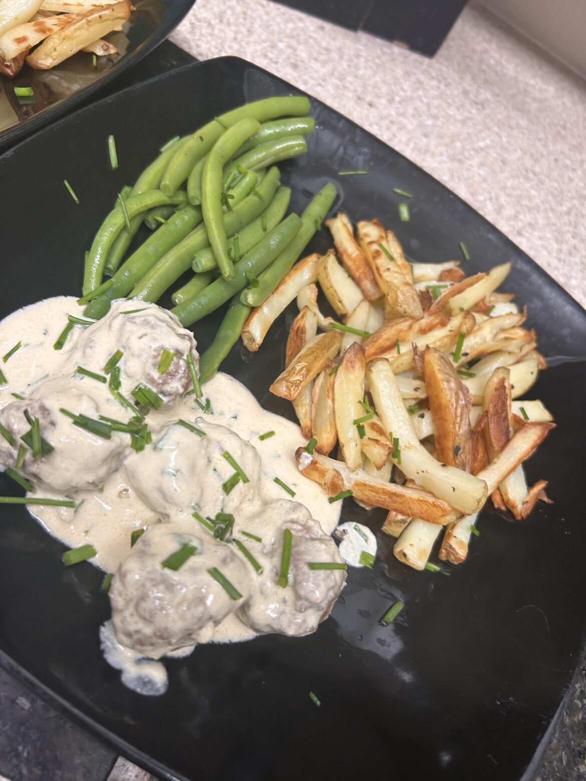 Pork meatballs in creamy chive sauce with chips and green beans