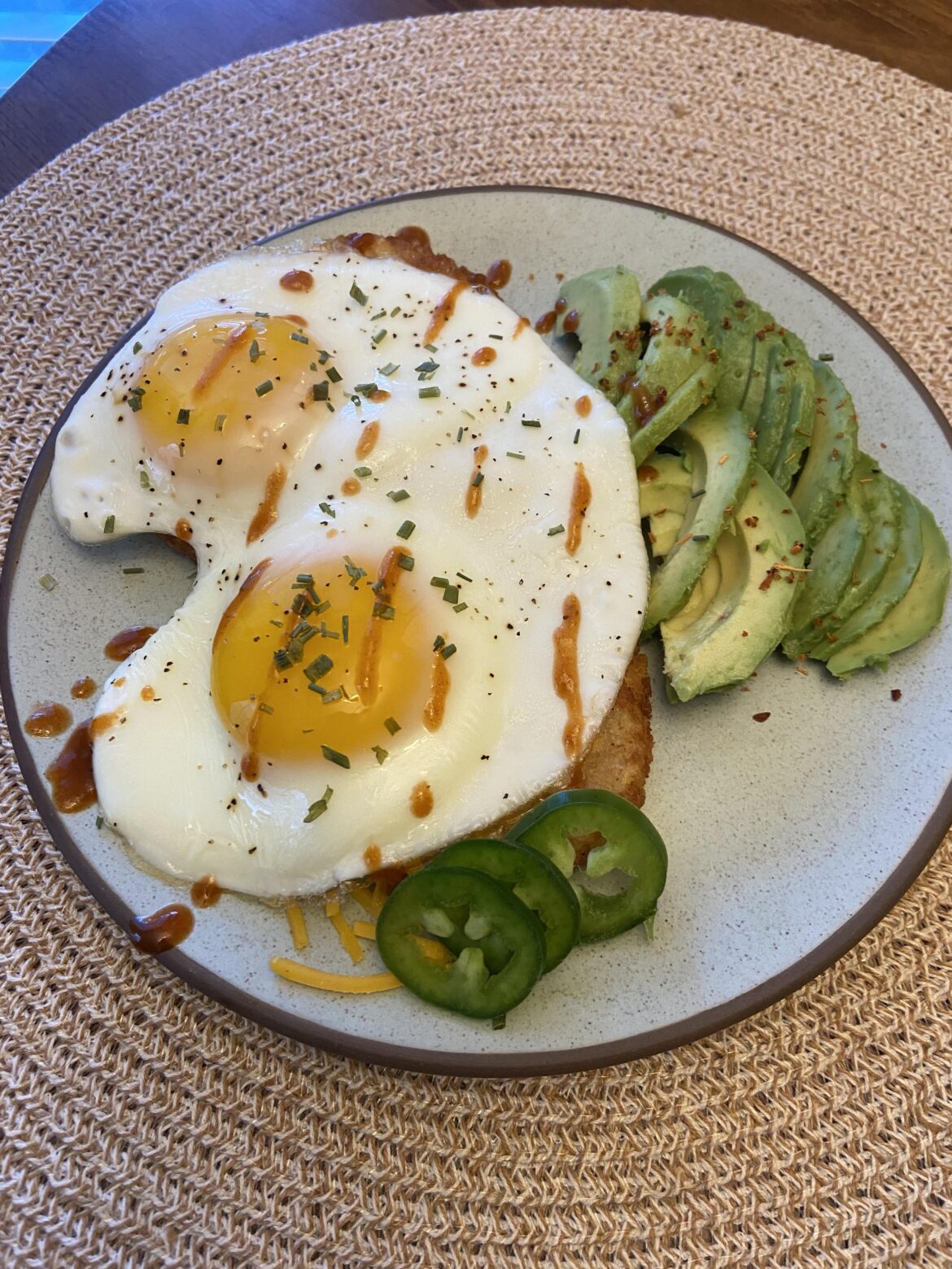 Made a couple sunny side ups over hashbrown with hot sauce (required) and avocado.