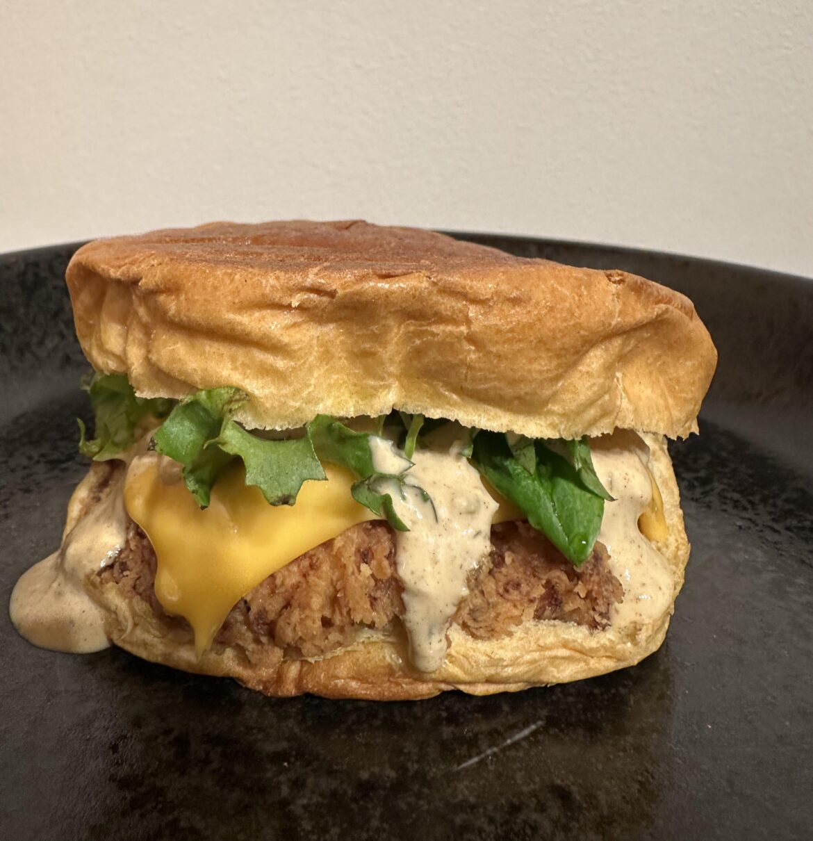 Homemade fried chicken sandwich with cheddar cheese, lettuce and sauce