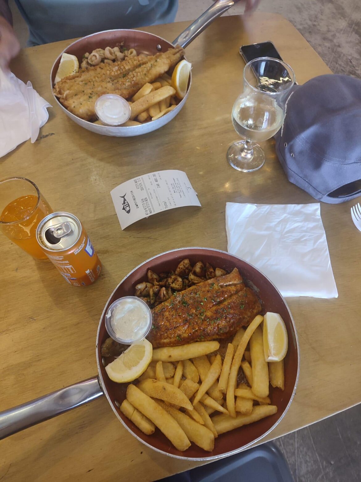 Hake, calamari and fries served in a frying pan