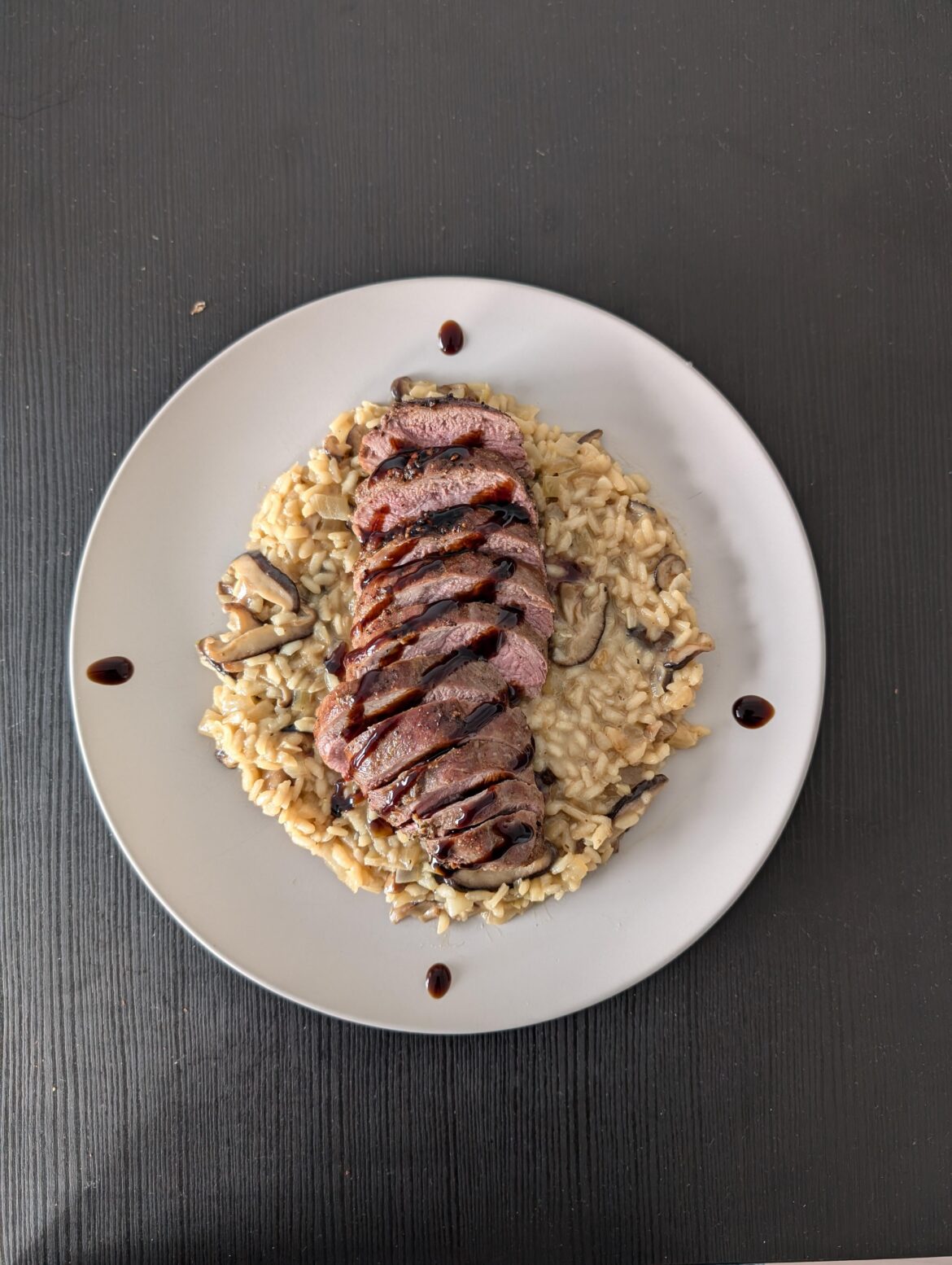 Creamy mushroom risotto with duck breast and some balsamic glaze
