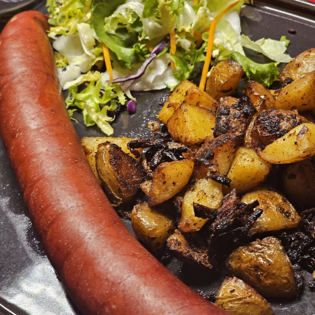 Typical Swiss dish: a "Ratsherren-Schüblig" (lit. "Councilor's Sausage", a traditional pretty heavy Swiss sausage) with fried potatoes and a side salad.
