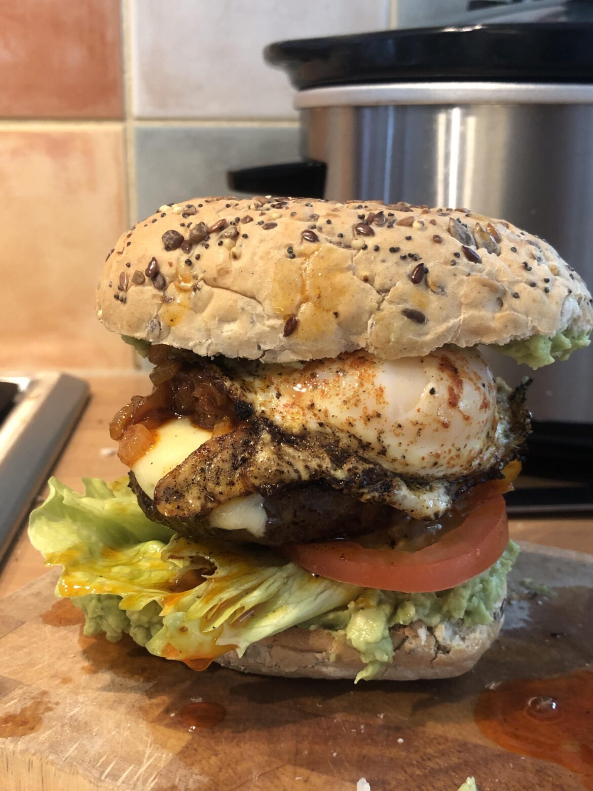 Homemade Burger with guacamole, beef tomato, caramelised onions, dirty fried egg and iceberg lettuce