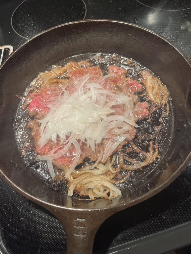 Grilled onions in the patty, raw onions on top. Paper thin.