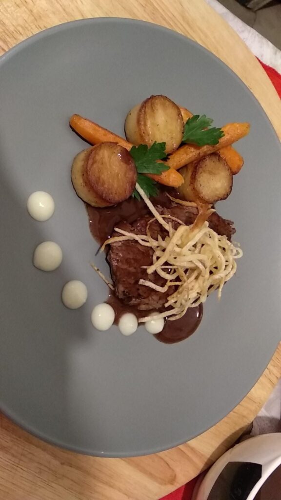 Beef breeze with gravy,buttered sauteed carrots,potato fondant, potato chips, potato puree and parsley.