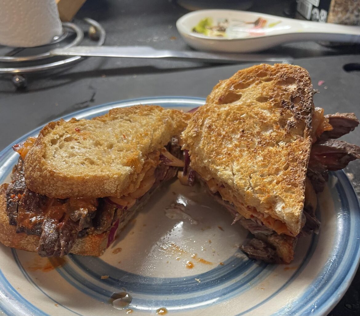 Leftover flank steak, homemade kimchi, red onion slices, and mayo on toasted French country bread