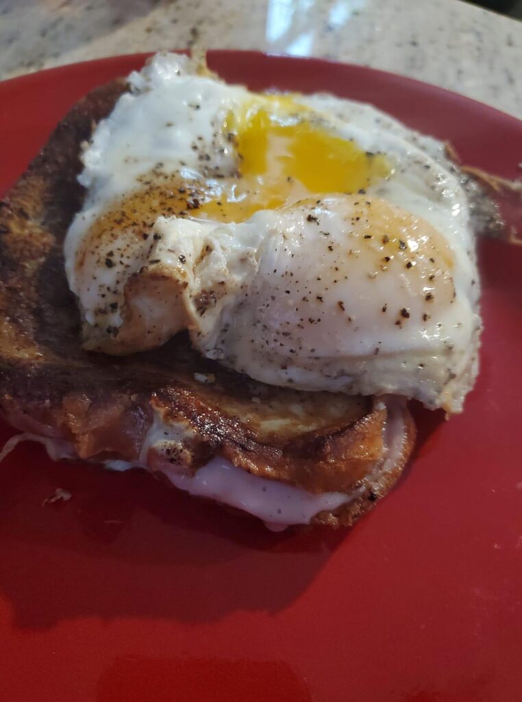 Cream cheese-stuffed French toast with strawberry preserves, orange zest, and juice, served with runny eggs