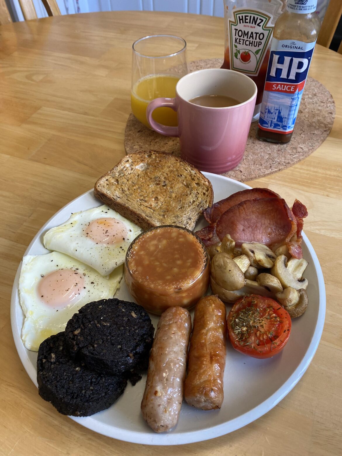 Saturday homemade breakfast: sausage, bacon, eggs, black pudding, mushrooms, tomato, beans, brown toast, orange juice and tea.
