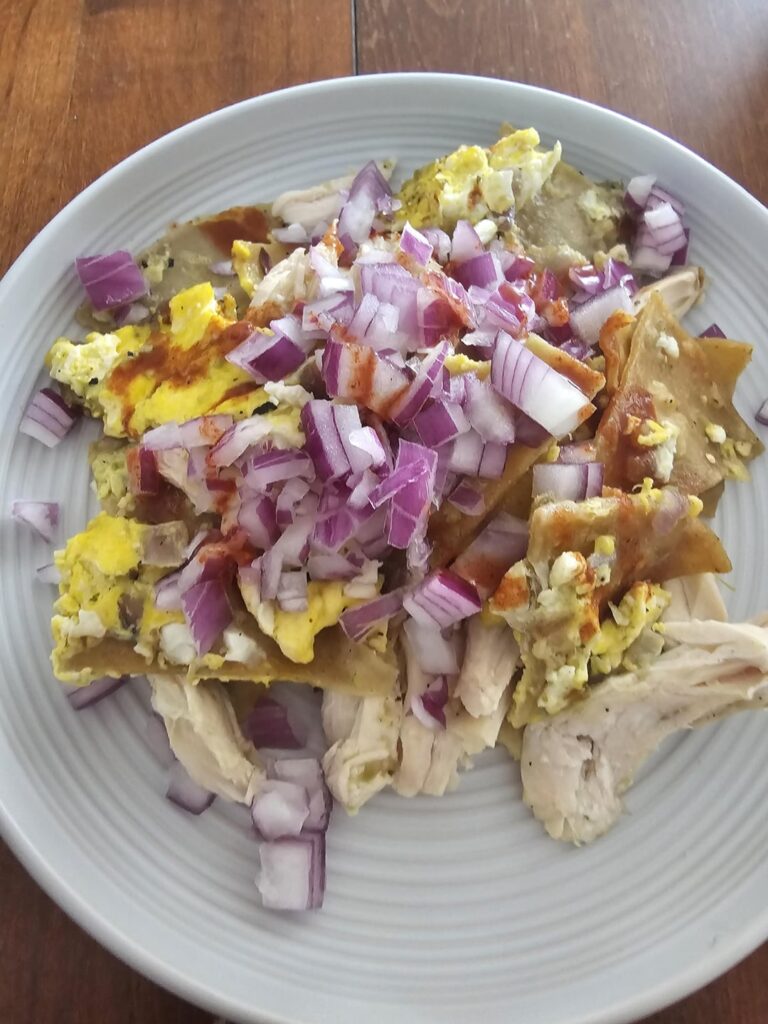 Chilaquiles topped with onion for breakfast
