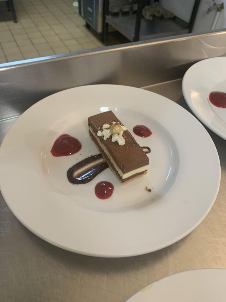 Trio of chocolate and hazelnut torte with raspberry compote and milk chocolate sauce with salted popcorn
