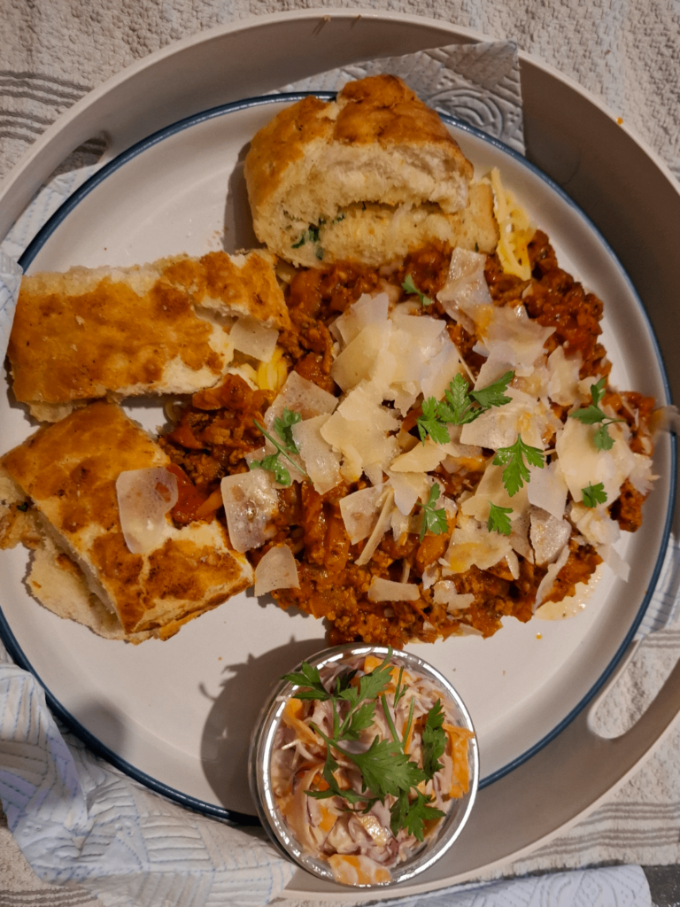 Home made spaghetti bol with parmesan shavings, home made cowlsaw, garlic tiger bread