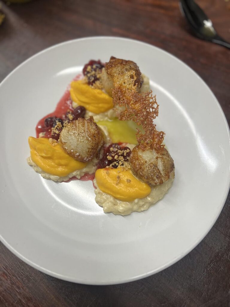 Scallops, butternut squash purée, hazelnut risotto, cranberry, Serrano-sage oil, manchego cheese crisp