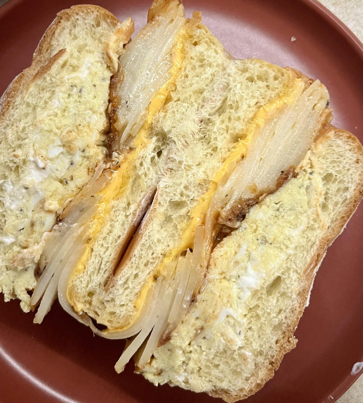 I don’t know how all of you are coping, but here’s a sloppy caramelized onion dip, French omelette, potatoes gratin, Firelli Extra Hot, American cheese and garlic butter situation on a potato bulkie.